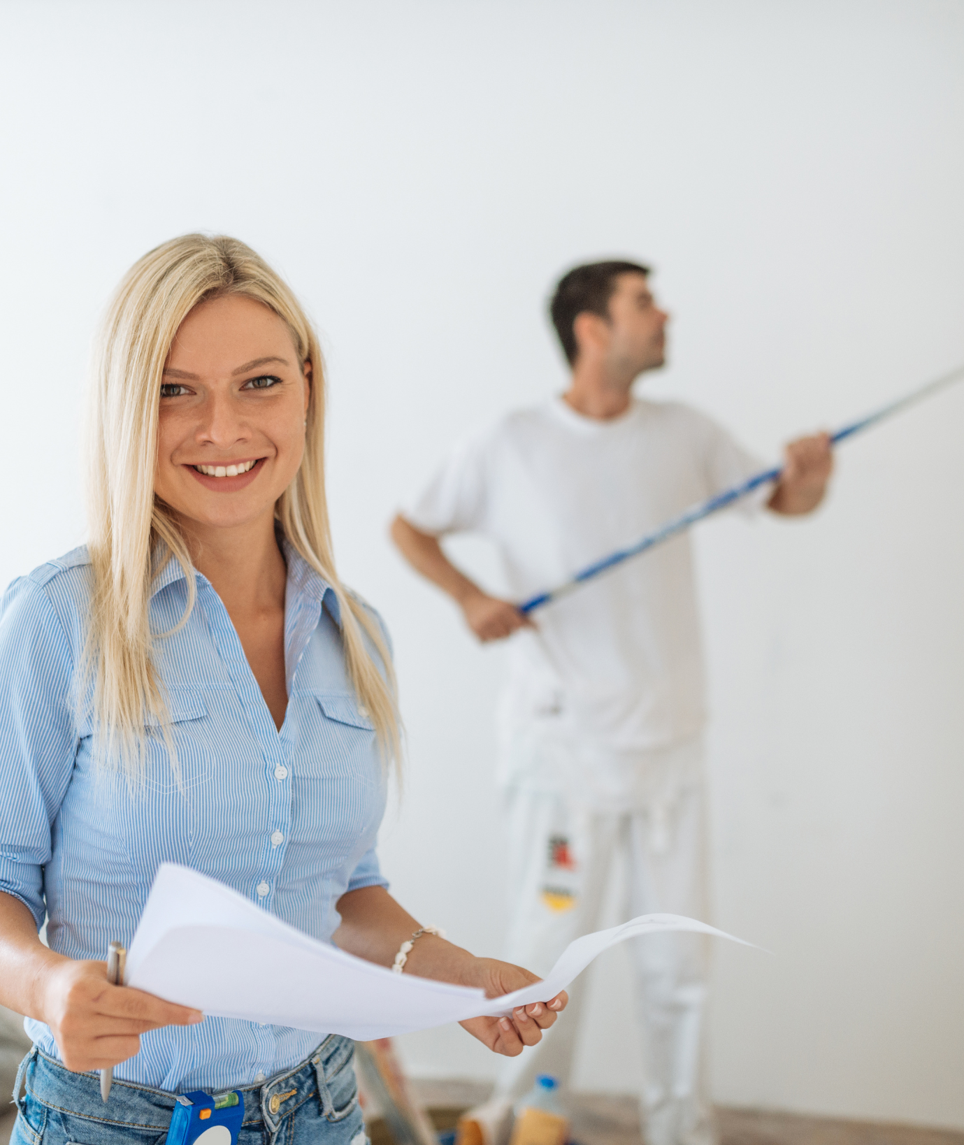 Coordinator reviewing an estimate while a painter works